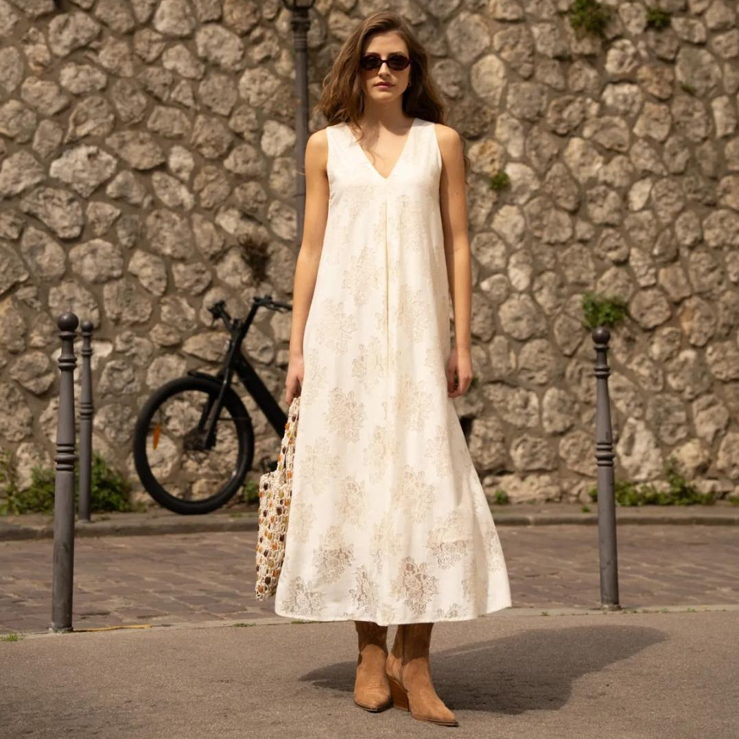 Besticktes Maxi-Kleid in Creme – Frontansicht mit V-Ausschnitt und floralem Muster in urbanem Setting