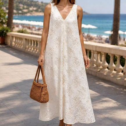 Florales Maxi-Kleid Creme – Frontansicht mit A-Linie und goldener Stickerei vor mediterraner Kulisse