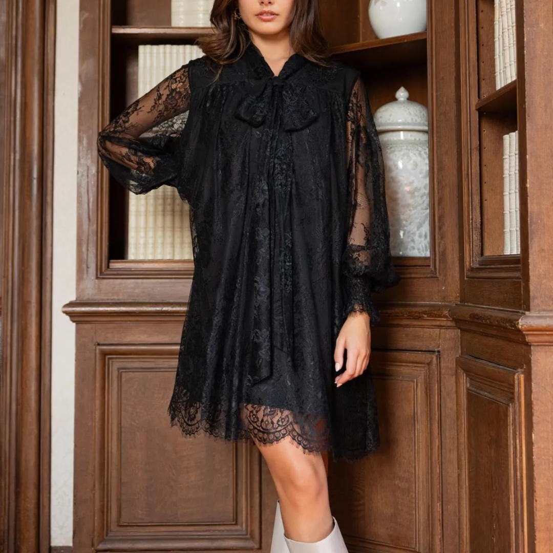 Schwarzes Spitzenkleid mit Schleife in voller Vorderansicht in elegantem Interieur
