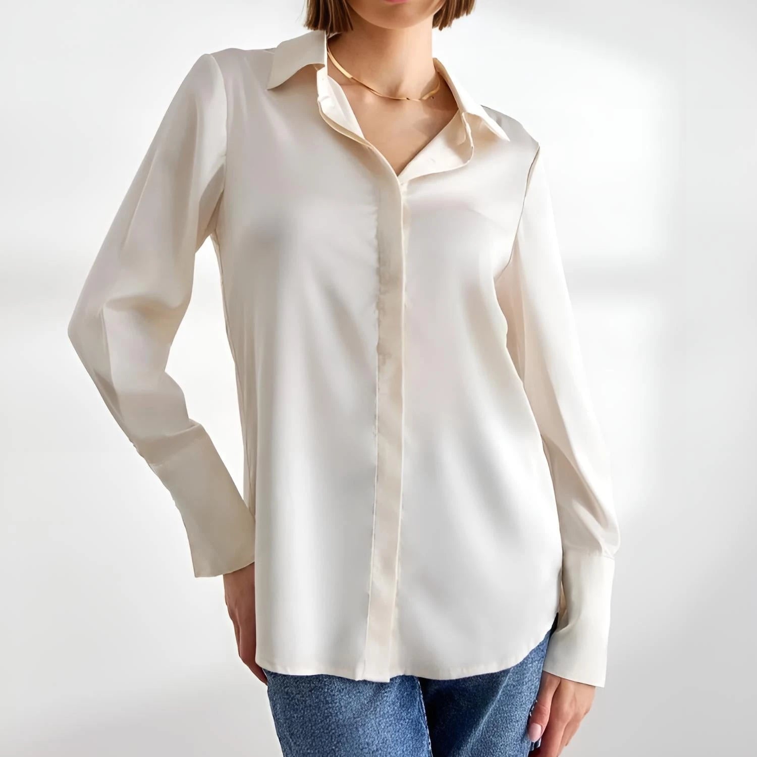 Damen-Satinbluse La Brillance creme mit Kragen, Manschettenärmeln und tailliertem Schnitt.