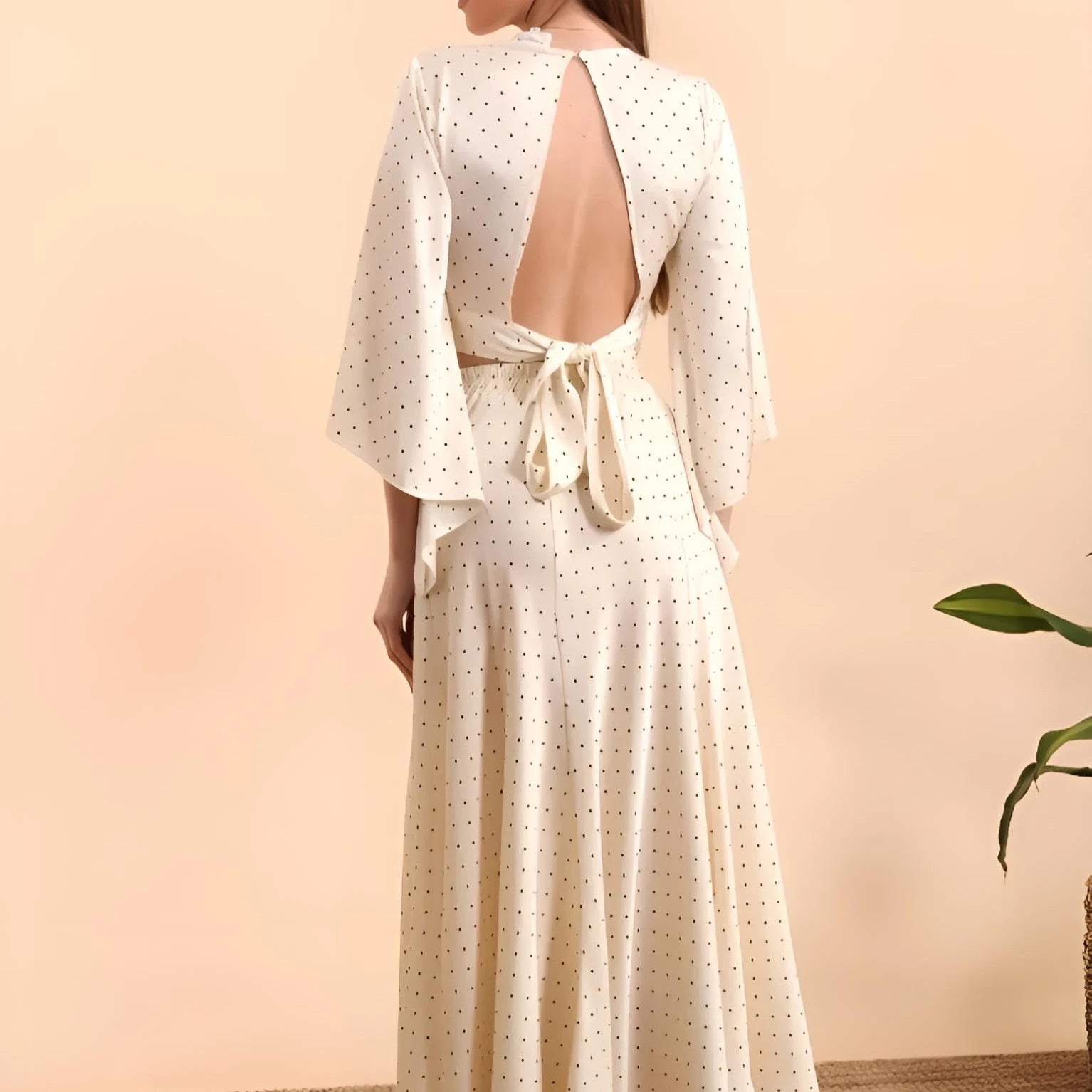 Elegante cremefarbene Satinbluse mit feinem Punktmuster, ausgestellten Ärmeln und modernem Rückenausschnitt mit Bindeband.