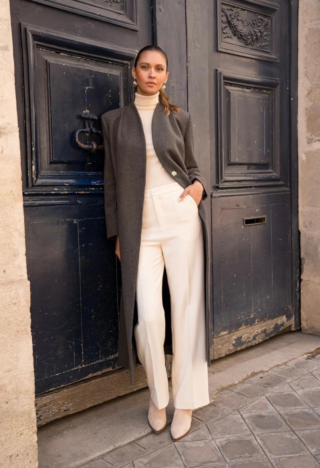 Langer Damenmantel Coffee offen getragen, kombiniert mit weißer Hose und Rollkragen für elegantes Outfit
