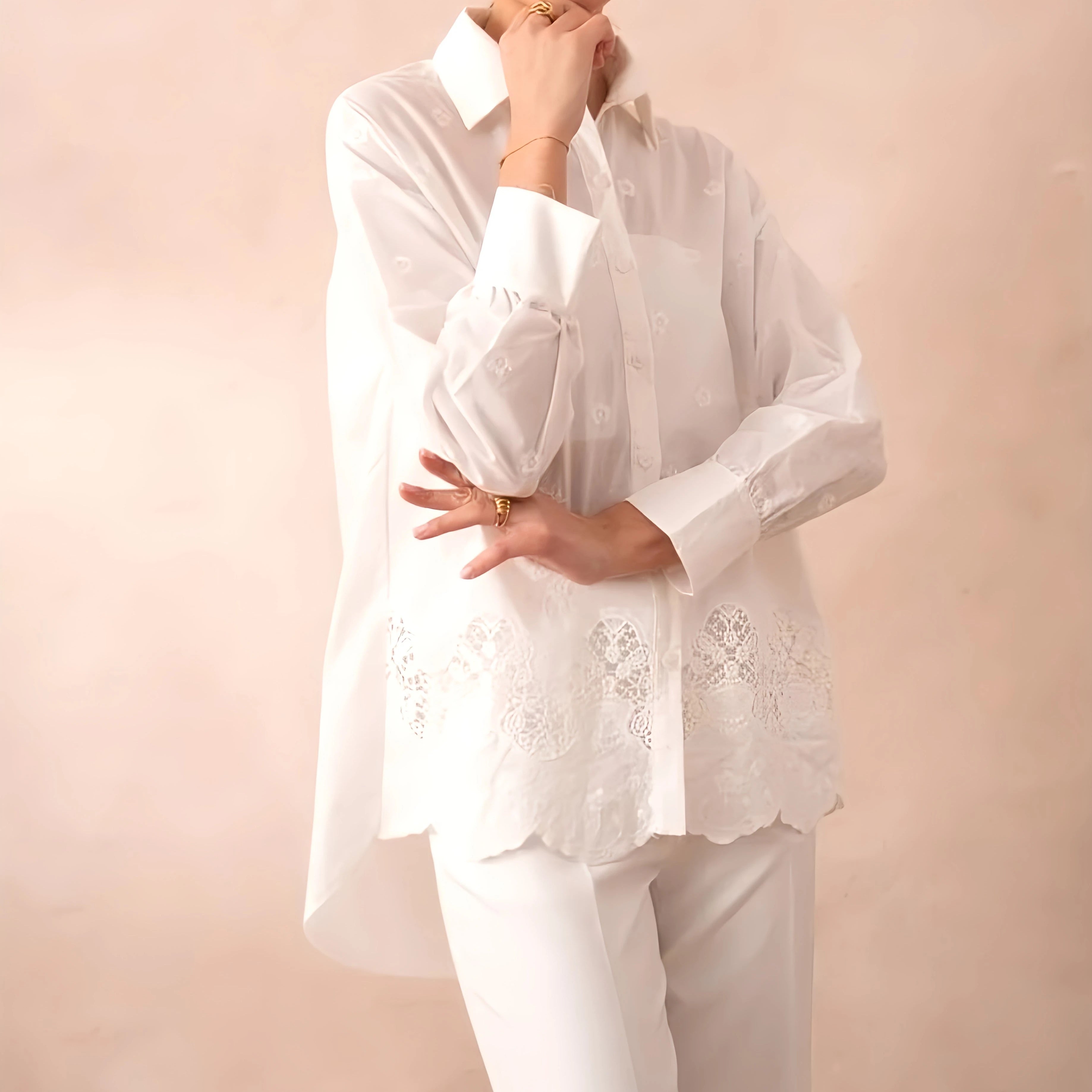 Weiße Oversized Spitzenbluse Isabella mit Stickereidetails, Hemdkragen und abgerundetem Saum.