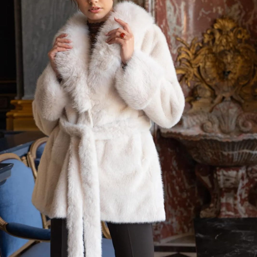 Elegante Fake Fur Jacke in Creme für Damen mit Bindegürtel und breitem Kragen, getragen von Model im luxuriösen Ambiente